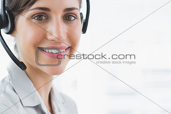 Brunette call centre agent smiling at the camera