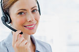 Call centre operator wearing headset smiling at camera