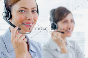 Smiling call centre agents with headsets at work