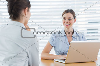Businesswoman smiling at interview candidate