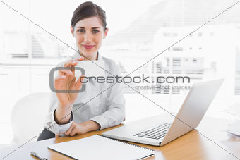 Happy businesswoman showing blank business card