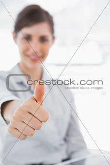 Young businesswoman giving thumb up