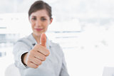 Young businesswoman giving thumb up and smiling