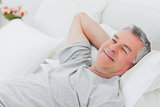 Smiling man relaxing in bed