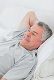 Cheerful man relaxing in bed