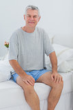 Cheerful man sitting in bed