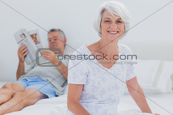 Mature woman sitting on bed