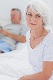Anxious mature woman sitting in bed