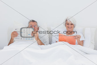 Mature people reading in bed