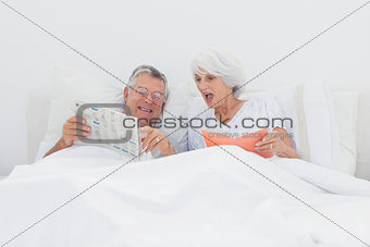 Mature man showing his newspaper to his wife