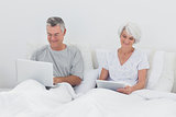 Mature man using a laptop in bed