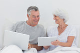 Mature man looking at wifes tablet pc