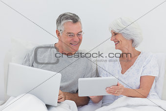 Mature man looking at wifes tablet pc