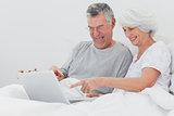 Mature man with wife pointing at a laptop