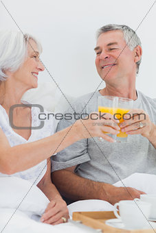 Couple clinking their orange juice glasses