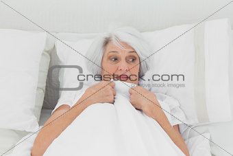 Fearful woman clutching her quilt