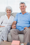 Mature couple hand in hand sitting on a couch