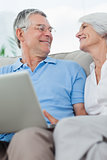 Couple using a laptop pc on the couch