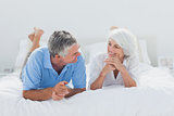 Couple lying and talking together in bed