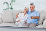 Couple watching television sitting on the couch