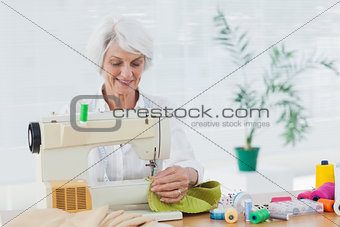 Retired woman using the sewing machine
