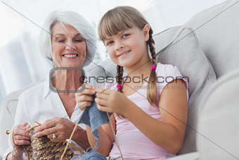 Young girl and her granddaughter knitting together