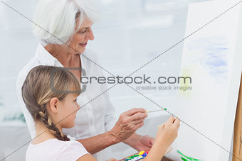 Grandmother and granddaughter painting together