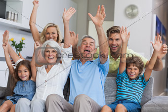 Multi-generation family raising their arms
