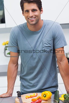 Handsome man leaning on the counter of his kitchen