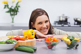 Cheerful woman leaning on the counter of her kitchen