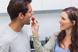 Woman feeding her husband cherry tomato