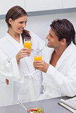 Couple clinking their glass of orange juice