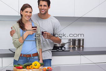 Delighted couple clinking their glasses of red wine