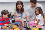 Woman with family pouring fruit from a blender