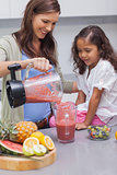 Woman pouring fruit from a blender