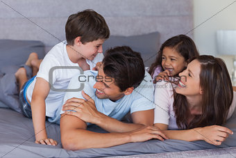 Happy family having fun on the bed
