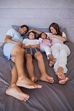 Happy family lying together on bed