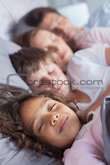 Family sleeping in bed