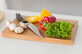 Chopping board in a kitchen with red and yellow pepper