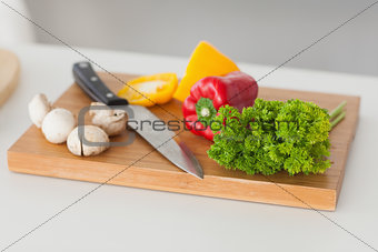 Chopping board in a kitchen with red and yellow pepper