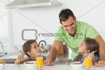 Father talking to his children while they are having breakfast