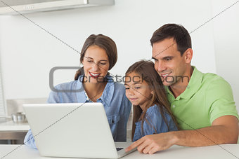 Family using a laptop on the kitchen table