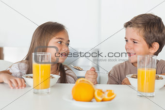 Siblings looking at each other during breakfast