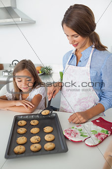 Mother giving a homemade cookie to her daughter
