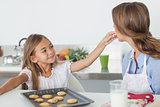 Young girl giving a cookie to her mother