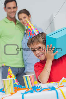 Little boy shaking his birthday gift