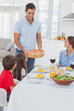 Man bringing a pizza to his family