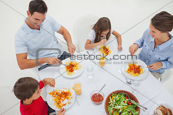 Overview of a family eating pasta with sauce and salad