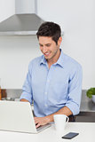 Man using a laptop in the kitchen