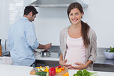 Pregnant woman holding her belly in the kitchen